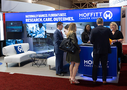 ASH conference attendees visit Moffitt Cancer Center booth on the exhibitor floor.